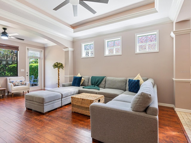 living room featuring crown molding, ceiling fan, dark wood-type flooring, and decorative columns