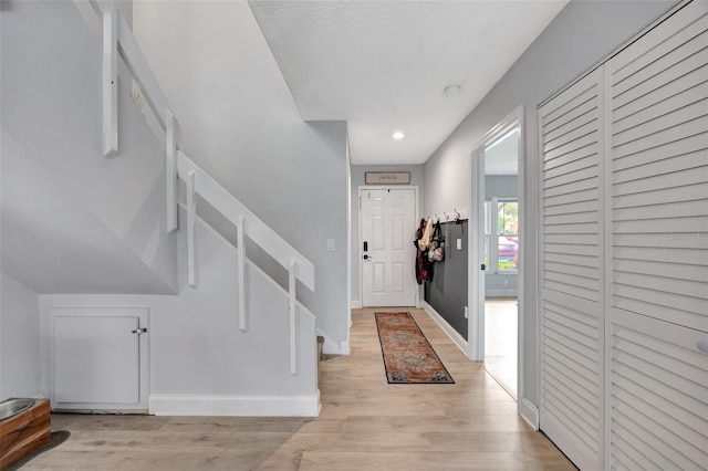 entryway featuring a textured ceiling and light hardwood / wood-style flooring