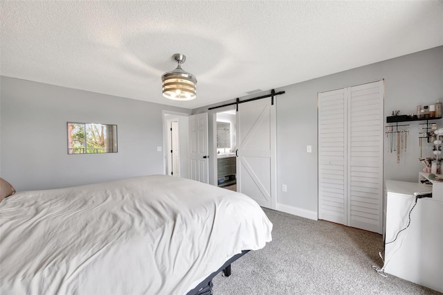 bedroom featuring a barn door, ceiling fan, a textured ceiling, and carpet floors