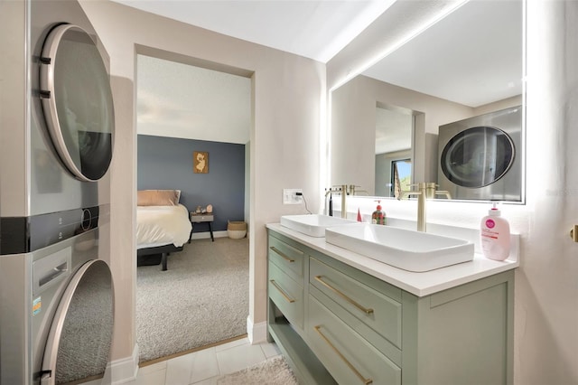 bathroom with stacked washing maching and dryer, tile patterned flooring, and vanity