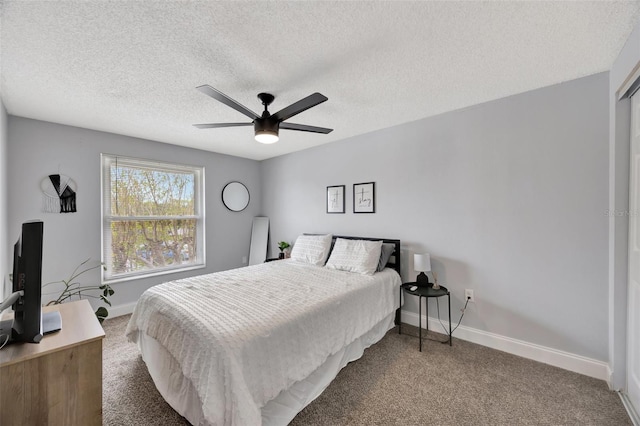 bedroom with a textured ceiling, carpet, and ceiling fan