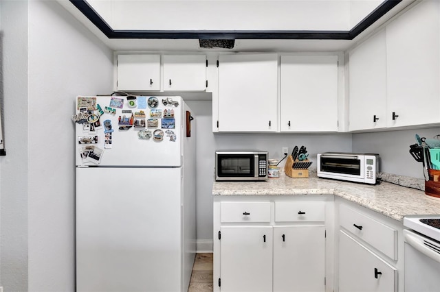 kitchen with white cabinetry and white appliances