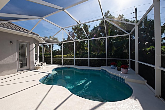 view of pool with a patio and glass enclosure