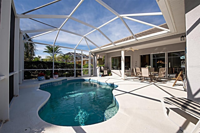 view of swimming pool featuring a patio, glass enclosure, and ceiling fan