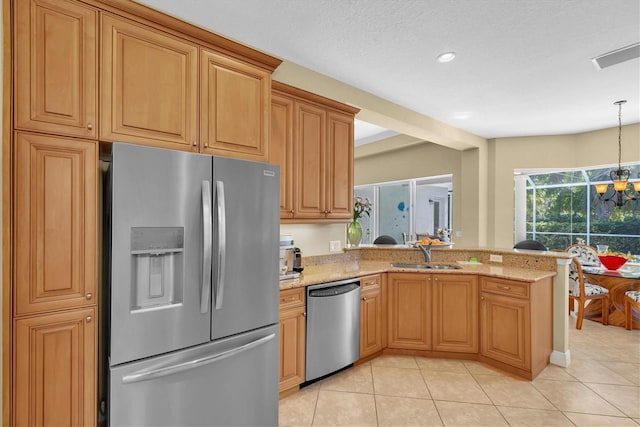 kitchen with an inviting chandelier, sink, light stone countertops, kitchen peninsula, and stainless steel appliances