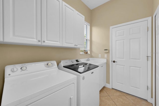 laundry area featuring washer and dryer, light tile patterned flooring, cabinets, and sink