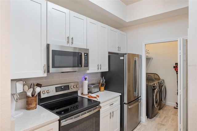 kitchen featuring tasteful backsplash, stainless steel appliances, washing machine and dryer, light hardwood / wood-style floors, and white cabinetry