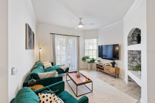 living room featuring light hardwood / wood-style floors, ceiling fan, and crown molding