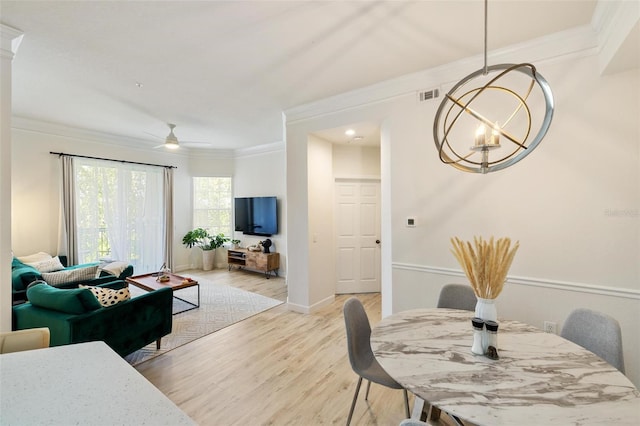 dining area with ceiling fan with notable chandelier, light hardwood / wood-style floors, and ornamental molding