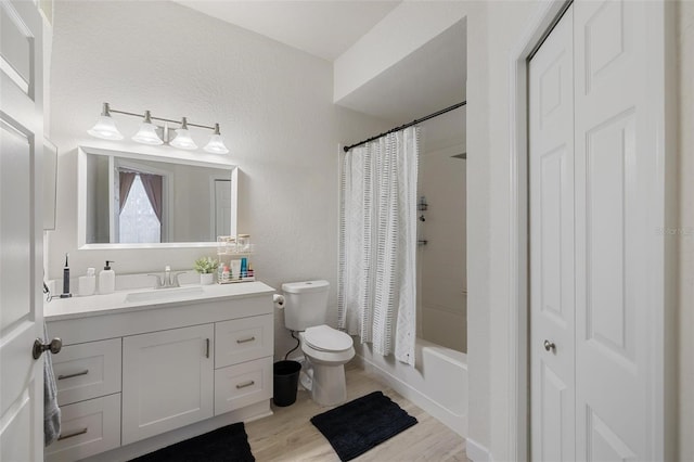 full bathroom with hardwood / wood-style floors, vanity, toilet, and shower / bath combo