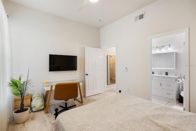 bedroom with ensuite bathroom, ceiling fan, and light hardwood / wood-style floors