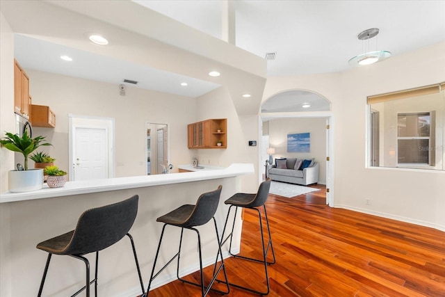 kitchen featuring a breakfast bar, dark hardwood / wood-style floors, and kitchen peninsula