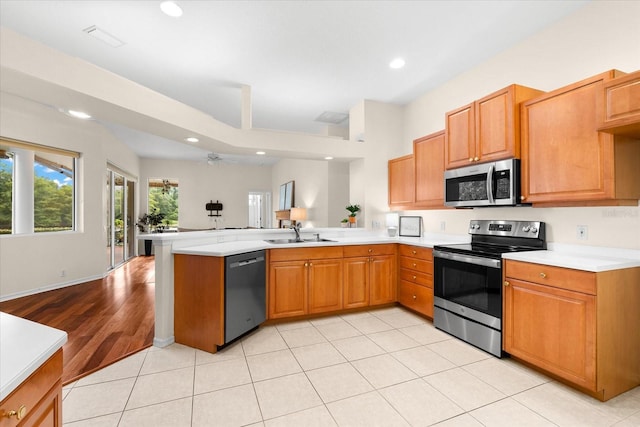 kitchen featuring ceiling fan, sink, kitchen peninsula, light tile patterned floors, and appliances with stainless steel finishes