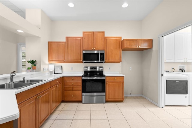 kitchen featuring washer / clothes dryer, sink, light tile patterned flooring, and stainless steel appliances