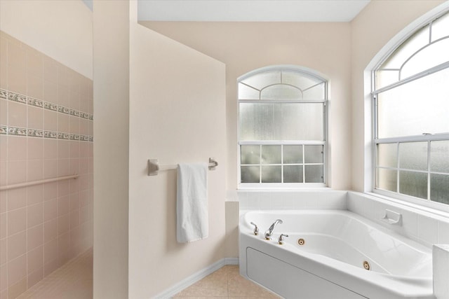 bathroom with tile patterned flooring and a tub