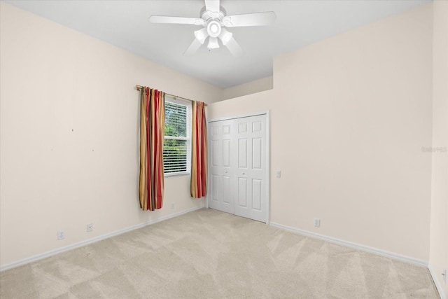 spare room featuring ceiling fan and light colored carpet