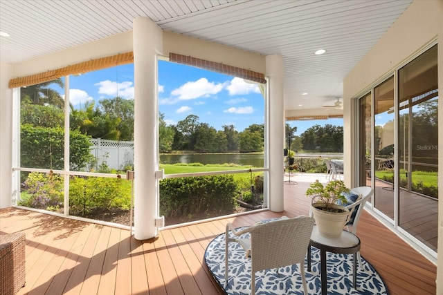 sunroom featuring a water view