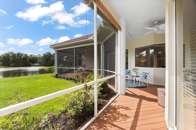 unfurnished sunroom with a water view and ceiling fan