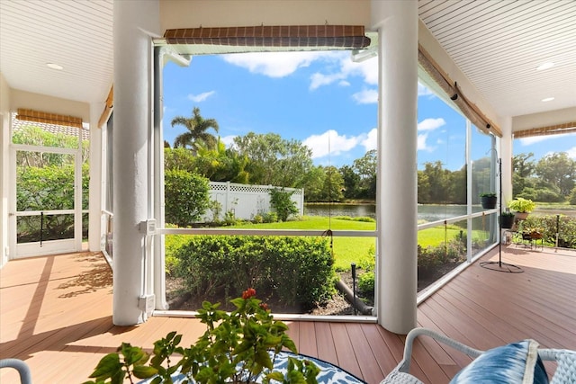 sunroom featuring a water view and a healthy amount of sunlight