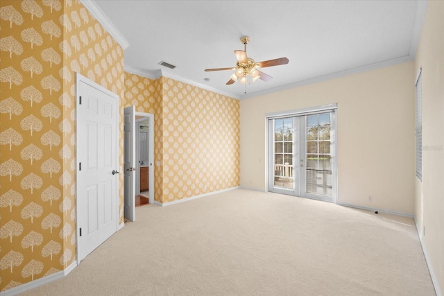 carpeted empty room with french doors, ceiling fan, and crown molding