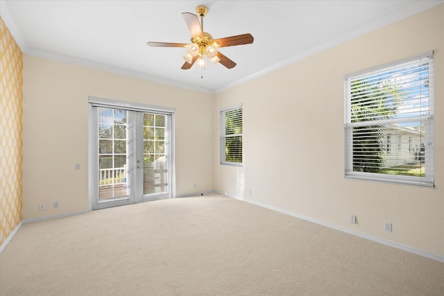 unfurnished room with ceiling fan, light colored carpet, ornamental molding, and french doors