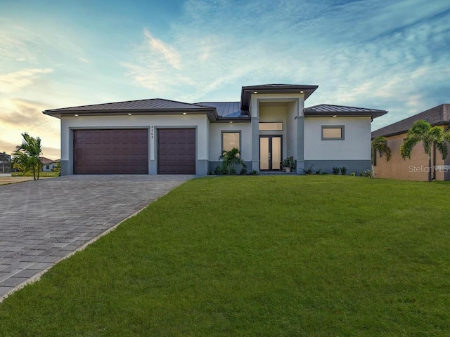 view of front of property with a garage and a yard