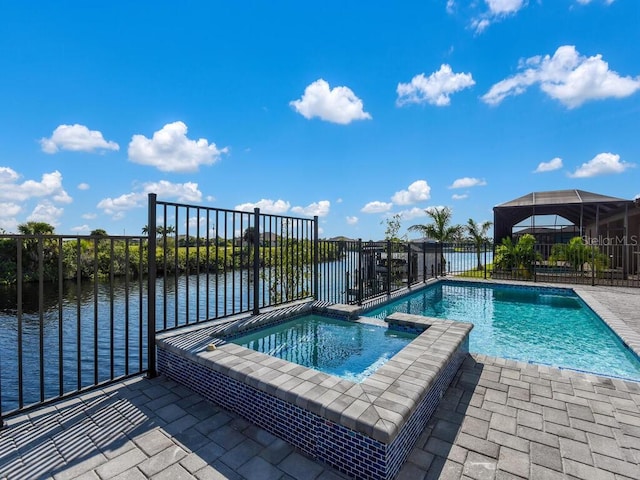 view of pool featuring a water view, glass enclosure, and an in ground hot tub