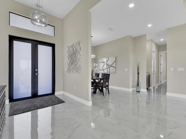 foyer entrance featuring french doors and an inviting chandelier