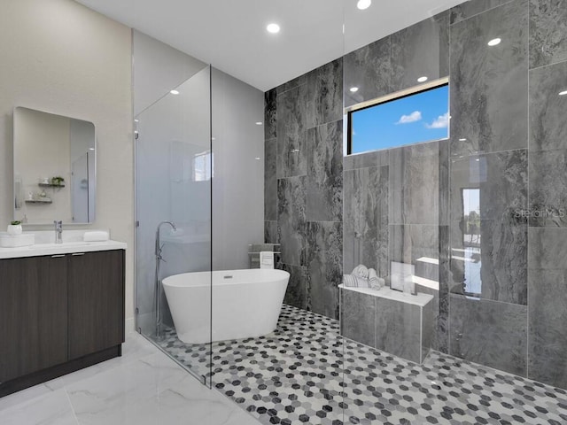 bathroom with separate shower and tub, vanity, and tile walls