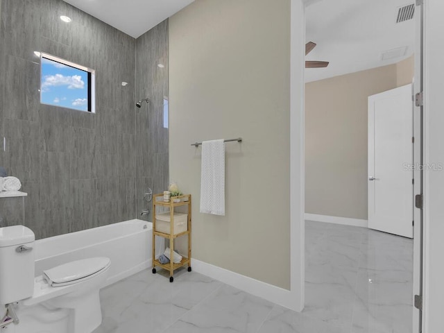 bathroom featuring ceiling fan, toilet, and tiled shower / bath combo