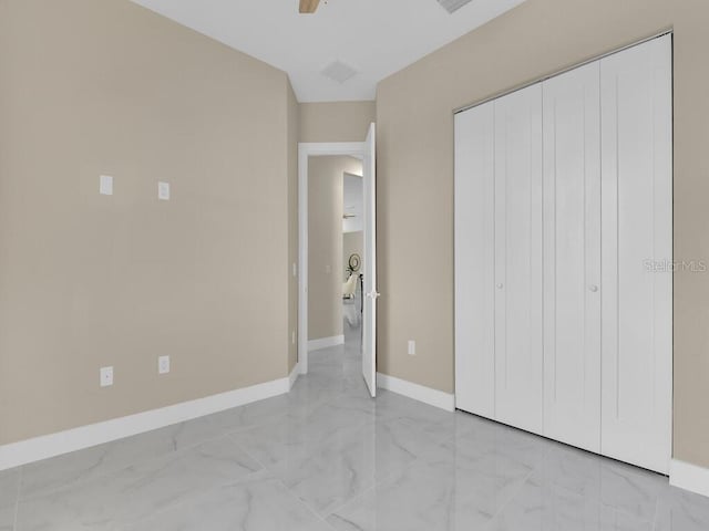 unfurnished bedroom featuring ceiling fan and a closet