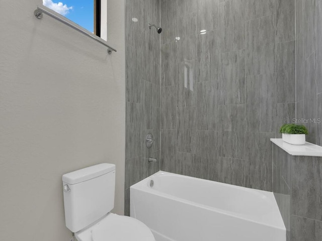 bathroom with tiled shower / bath and toilet