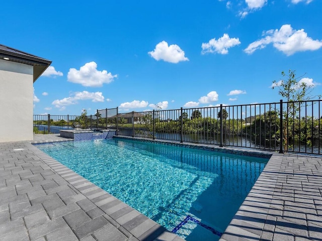 view of pool featuring a water view, an in ground hot tub, and a patio area