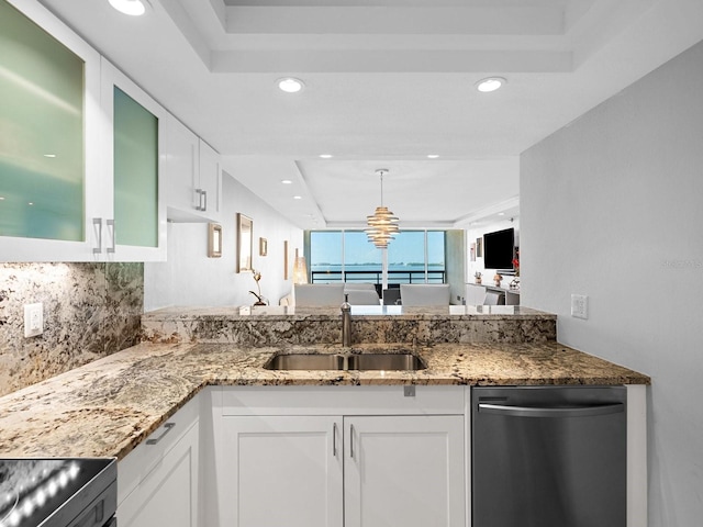 kitchen with white cabinetry, a raised ceiling, light stone countertops, and stainless steel dishwasher