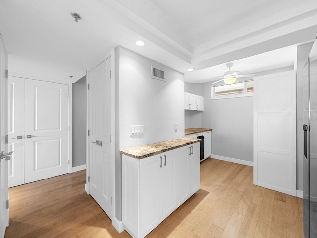 kitchen with white cabinetry, light wood-type flooring, and ceiling fan