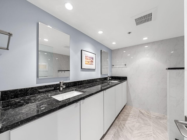 bathroom featuring tile walls, vanity, and walk in shower