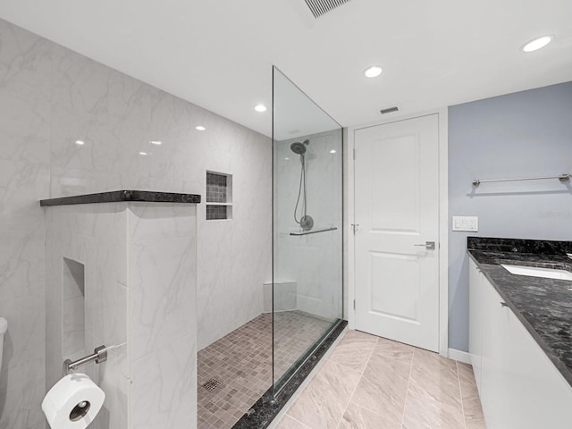 bathroom featuring vanity and tiled shower