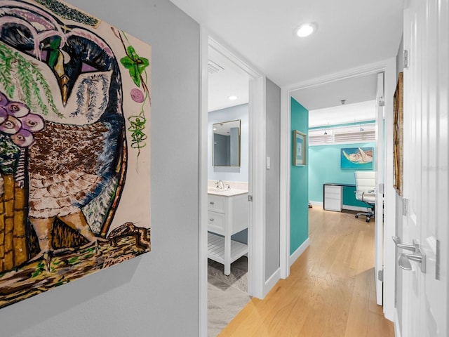 corridor with sink and light hardwood / wood-style floors