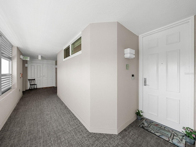 hallway featuring carpet and a textured ceiling