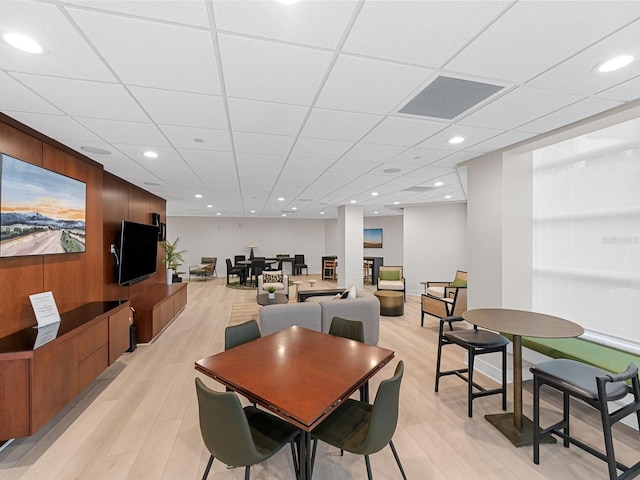 dining room featuring a drop ceiling and light wood-type flooring