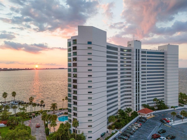 outdoor building at dusk with a community pool and a water view