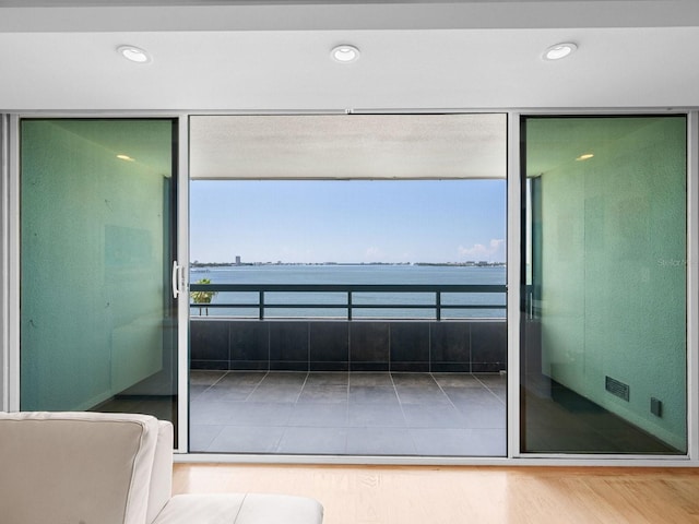 interior space featuring recessed lighting, a water view, and light wood-style flooring