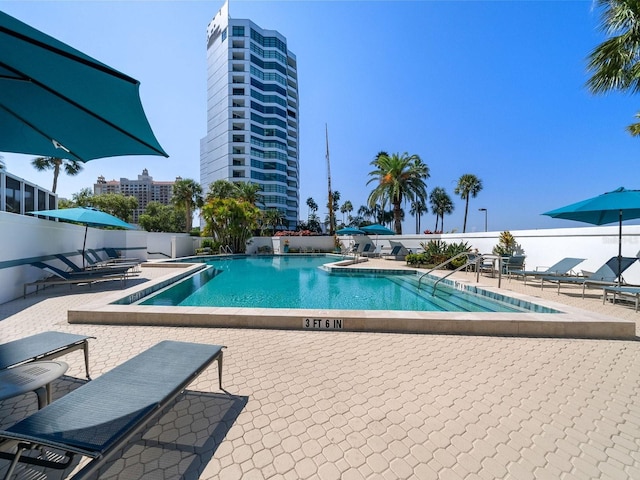 pool featuring a patio area, a view of city, and fence