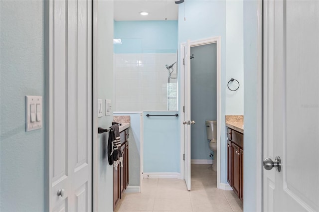 bathroom featuring vanity, a shower, toilet, and tile patterned floors