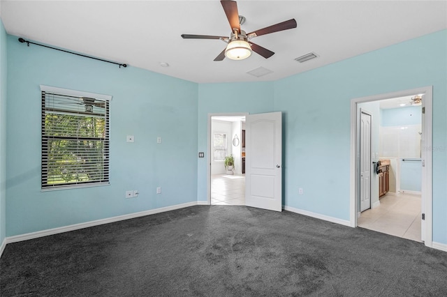 unfurnished bedroom with connected bathroom, light carpet, and ceiling fan