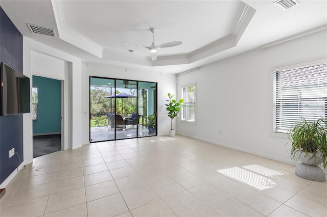 tiled spare room featuring ceiling fan, crown molding, and a tray ceiling