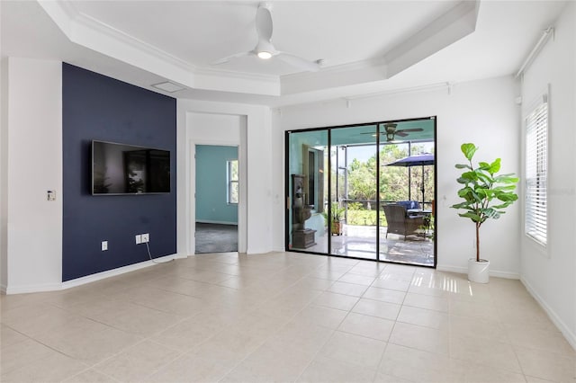 tiled empty room with a tray ceiling and ceiling fan