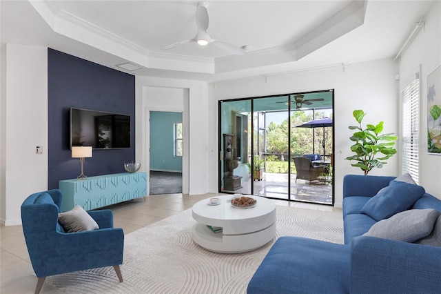 tiled living room featuring ceiling fan and a raised ceiling