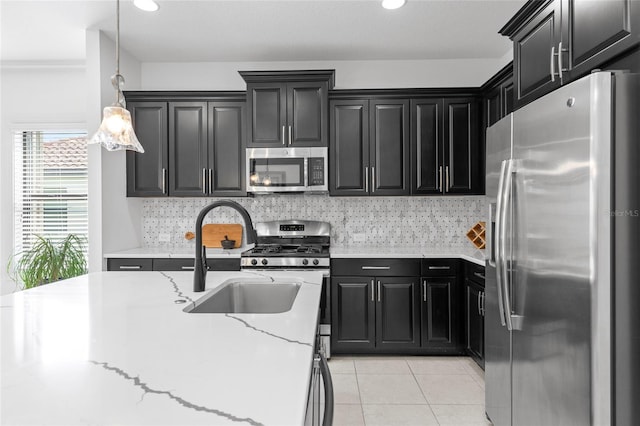 kitchen featuring light tile patterned floors, light stone countertops, sink, pendant lighting, and stainless steel appliances