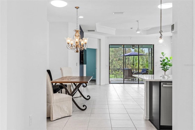 dining room with a raised ceiling, light tile patterned flooring, and ceiling fan with notable chandelier